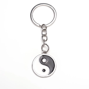 Detailansicht des Yin Yang Tai Chi Glasanhängers an einem silbernen Schlüsselanhänger