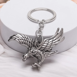 Detailed silver owl-shaped metal keychain with realistic feather texture on white background