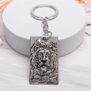 Gothic lion head relief keychain in antique silver finish with metal keyring on white fur