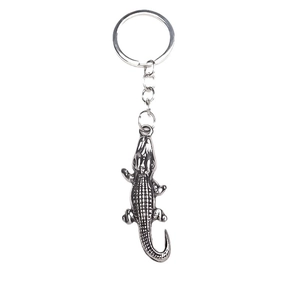 Porte-clés crocodile en métal argenté vintage avec détails d'écailles sur fond blanc