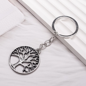 Vintage silver Tree of Life keychain with hollow round pendant on white aesthetic background