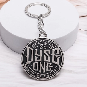 Porte-clés Dyse One rond en métal de style industriel avec relief argenté sur socle