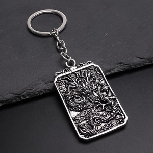 Vintage silver dragon totem metal keychain with detailed dragon relief on stone surface