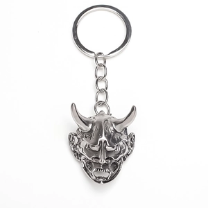 Macro shot of silver metal Hannya mask keychain with detailed horns and fangs