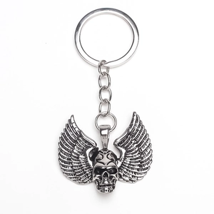Macro detail of retro silver skull and feathered wing keychain with metal ring