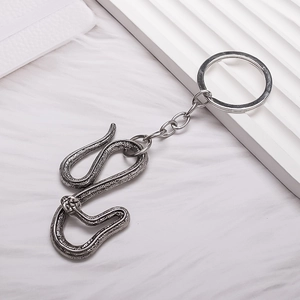 Vintage silver snake keychain with detailed scale texture on white minimalist background