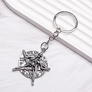 Punk style antique silver keychain with star and skull pendant on white marble