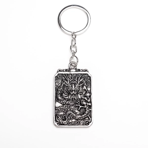 Macro detail of silver dragon totem relief on rectangular metal keychain pendant