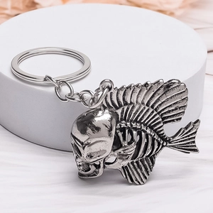 Close-up of vintage silver fish skeleton keychain with a detailed punk skull head