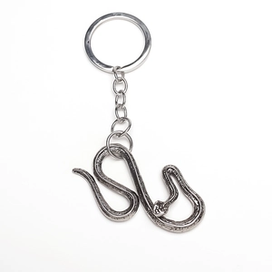 Macro detail of retro alloy snake keychain featuring intricate scale textures and silver finish