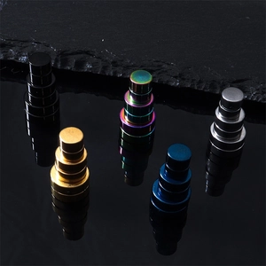 Boucles d'oreilles magnétiques rondes noires, dorées et bleues sur fond noir réfléchissant