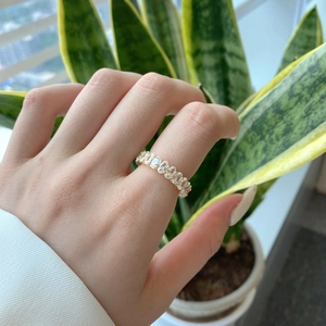 Close-up of a gold ring with oval-cut cubic zirconia in a full eternity band setting
