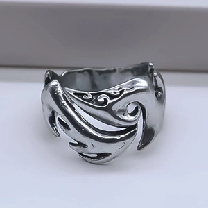 Detail showing vintage silver alloy ring with intricate hollowed flame pattern engraving