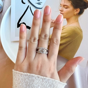 Classic silver-tone S925 ring with round cut zircon and intertwined diamond band on finger