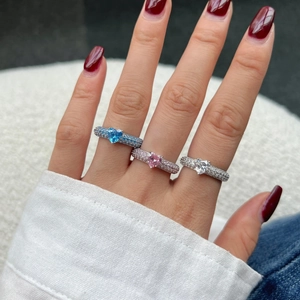 Detailed view of three S925 silver heart rings with colorful zircons on a model hand