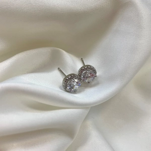 Macro shot of silver S925 sterling silver halo stud earrings with sparkling round zirconia
