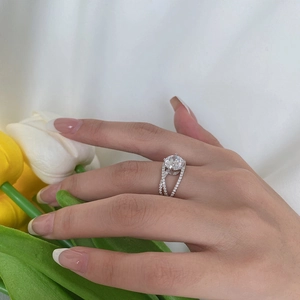 Close-up of s925 silver wedding ring with round solitaire and intertwined diamond band