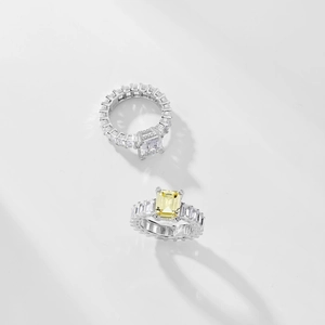 Detail of emerald cut rings with yellow and white stones and square pave settings