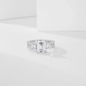 Macro detail of emerald-cut gemstone and rectangular diamond-encrusted silver band
