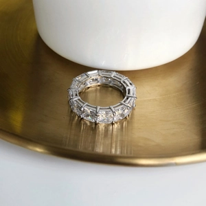 Detail of eternity ring with princess cut cubic zirconia on a brushed metal surface