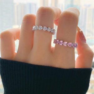Close-up of S925 sterling silver rings with pink heart-shaped row of cubic zirconia stones