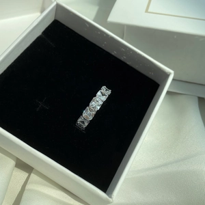 Detail of five-stone silver ring with square-cut cubic zirconia in a jewelry box