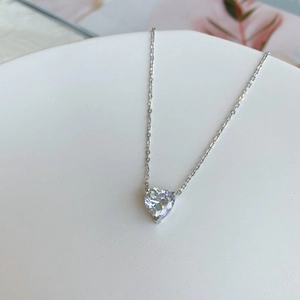 Detail of S925 silver necklace with heart-shaped zircon pendant on white display