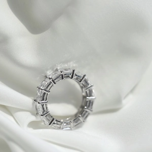 Detailed close-up of S925 silver eternity ring with baguette-cut zircons on silk
