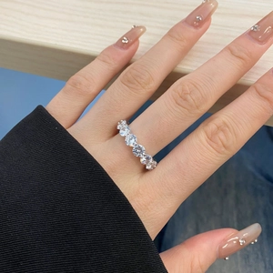 Detailed view of an S925 sterling silver eternity ring with zircon stones on a wooden background