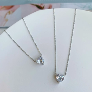 Detailed shot of S925 sterling silver necklaces with heart-shaped zircon pendants on a tray
