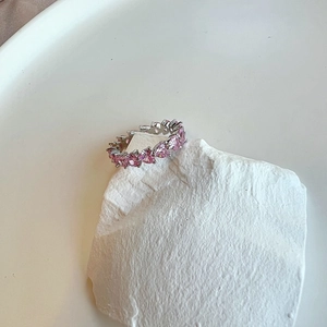 Macro shot of S925 sterling silver band with pink heart-shaped cubic zirconia stones
