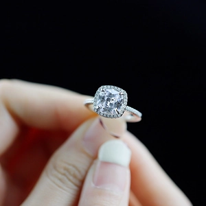 Gros plan d'une bague en argent avec zircon taille coussin et serti halo chic