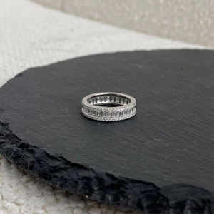 Detailed macro view of silver eternity ring with baguette-cut and pave-set zircons