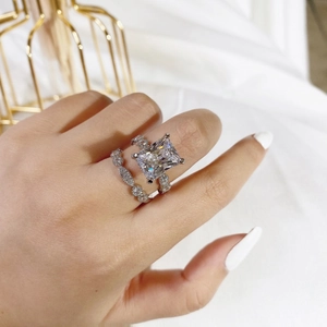 Macro shot of silver wedding ring set with radiant cut stone and marquise pavé band