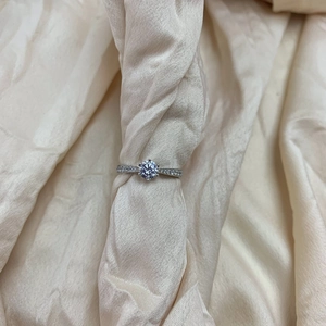 Detail eines klassischen sechsarmigen Silberrings mit Karbon-Diamant auf Champagnersatin