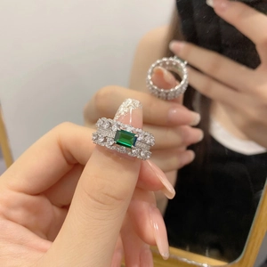 Close-up of S925 silver ring featuring emerald-cut green stone and pavé zircon rows
