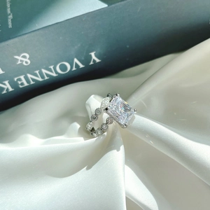 Elegant emerald cut silver bridal ring set with sparkling zirconia on white silk background