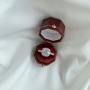 Detailed view of square cut zircon silver ring in luxury red velvet octagonal jewelry box