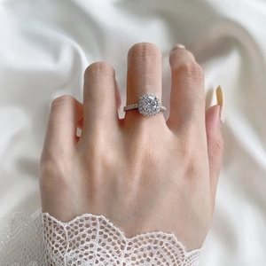 Close-up of S925 sterling silver halo ring with large round zircon on silk fabric