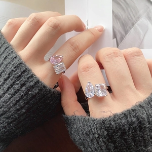 Detalle de anillo en plata S925 con circonita rosa de pera y piedra cuadrada transparente