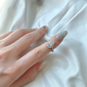 Close-up of S925 silver pear-shaped halo ring with pavé-set zircons on hand