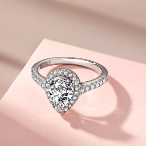 Macro detail of S925 sterling silver pear-shaped ring with halo of sparkling zircons