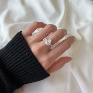 Macro shot of a S925 silver pear shaped drop ring with zircon diamonds on model's finger