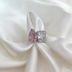 Detailed view of dual-stone silver ring with pear pink diamond and radiant white zircon