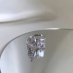 Detalle de anillo de plata S925 con piedras de circonita en forma de pera y esmeralda