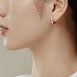 Boucles d'oreilles huggies en argent S925 avec zircons portées par un mannequin