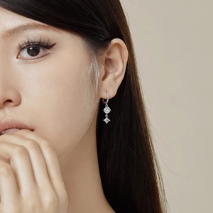 Gros plan de boucles d'oreilles S925 en argent avec zircons ronds et en losange