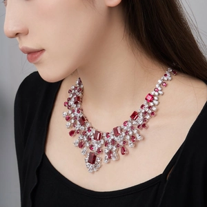 Macro detail of luxury silver necklace with red rubies and cubic zirconia on neck