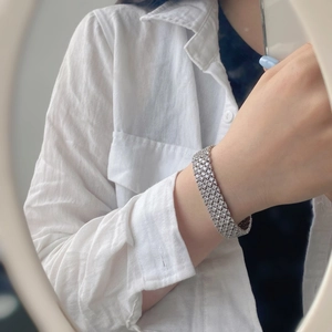 Close-up of wide multi-row sparkling zircon tennis bracelet on woman's wrist