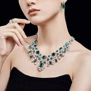Close-up of luxury S925 silver emerald and diamond necklace set on elegant model